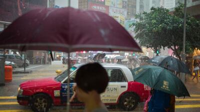 Pedestrians walk with umbrellas during a heavy downpour as a black rain alert was issued later in the afternoon by the Hong Kong Observatory amid inclement weather patterns from incoming Typhoon Haima, in Hong Kong's Causeway Bay district. AFP