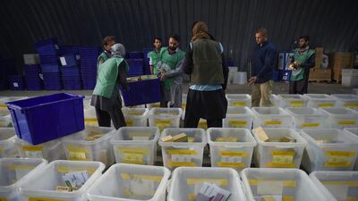 Afghan employees of the Independent Election Commission (IEC) load biometric devices in to boxes at a warehouse in Kabul. AFP