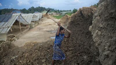 A woman digs the ground to collect soil and make bricks at a factory on the outskirts of Yangon. Demand for property in Yangon has surged as Myanmar undergoes rapid change since shedding the isolation of junta rule. Ye Aung Thu / AFP Photo