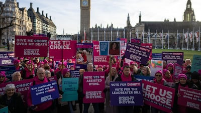 Campaigners hold placards as they protest in support of assisted dying in London. Getty Images