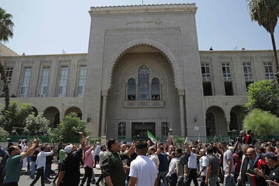 Syrians gather as they celebrate in front of the Palace of Justice after the court proceedings in Damascus. AFP