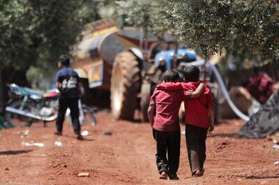 Displaced Syrian children walk together in an olive grove at Atmeh in Idlib province on May 15, 2019. Reuters