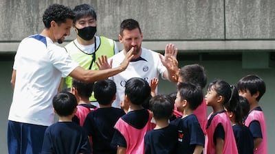 Paris Saint-Germain players Lionel Messi and Marquinhos high-five young participants while attending a soccer clinic at a stadium in Tokyo on July 18, 2022, as a part of the team’s pre-season summer tour of Japan. AFP