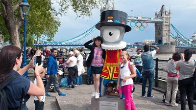 1st: London. Tourists pose for pictures beside a model of the 2012 Olympic mascot Mandeville near London’s Tower Bridge. Will Oliver / AFP