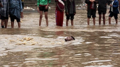 A man swims in flood waters on a street following a heavy day of rain in Sanaa, Yemen. Hani Mohammed / AP Photo