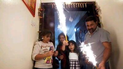 Indian expatriates in Abu Dhabi Sudhir Menon (right to left), Purna Hemnani, 7, Nidhi Menon, and Sharanya, 12, light sparklers in their apartment during Diwali, the Indian festival of lights.