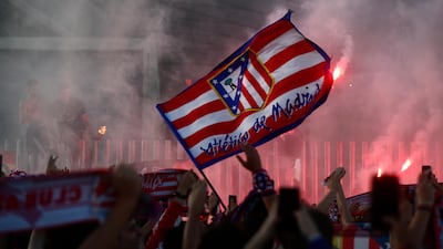 Atletico Madrid fans wave flags and set off flares in celebration outside the stadium after the match. Reuters