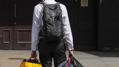 A man holds bags and suit carriers as he leaves the offices of Deutsche Bank in London, UK, on Monday. Bloomberg