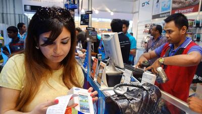 Shoppers buy smartphones at the Abu Dhabi Electronics Shopper show at ADNEC. Delores Johnson / The National