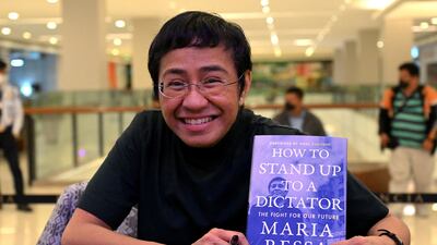 Ressa poses with a copy of her book at a mall in Pasig, the Philippines, in December 2022. AFP