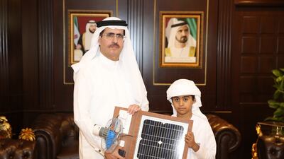Saeed Mohammed Al Tayer, MD & CEO of Dubai Electricity and Water Authority (DEWA), presented a certificate of appreciation and iPad to Ali Blaisha Al Muhairi, a nine-year-old Emirati inventor for his innovative ideas on sustainable energy. Courtesy Government of Dubai