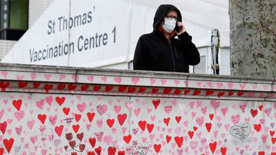 A man stands behind the National Covid Memorial Wall in London. Reuters