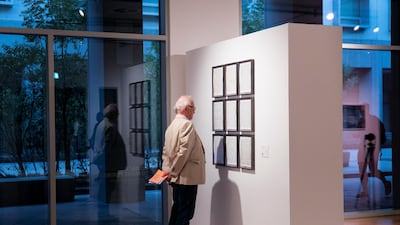 'Go Back to Move Forward' by British-artist Idris Khan shows a series of nine stamped music sheets. Each are individually framed, the melodies in them rendered illegible by a blur of white text. Reem Mohammed / The National
