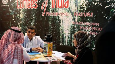 Visitors sit on a stand that promotes Indian coffee at the Gulfood exhibition in Dubai. Satish Kumar / The National