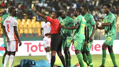 Referee Salima Mukansanga shows a yellow card to Guinea captain Naby Keita. EPA