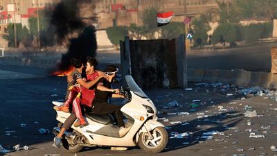 An injured protestor is rushed to the hospital after being shot during a demonstration in Baghdad, Iraq. AP