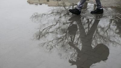 Residents navigate a flooded street in Abu Dhabi. Mona Al Marzooqi / The National