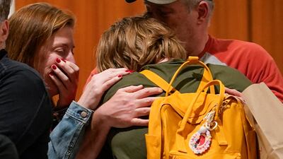 People are reunited with family members at a library after being removed from the scene of last week's shooting in Washington. AP