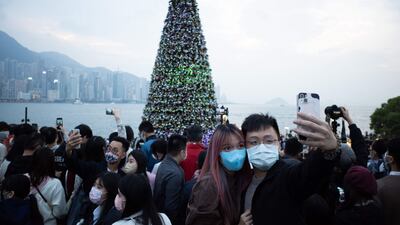 A couple pose for a photo in front of a giant Christmas tree at the West Kowloon cultural district in Hong Kong. AFP