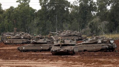 Israelis stand near their Merkava tanks at a gathering point next to the Israeli border with Gaza on March 29, 2019. EPA