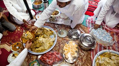Abdullah Al Yalyle dishes up for his guests during a traditional meal at his home Majlis in Wadi Al Tuwa, Ras Al Khaimah, United Arab Emirates.