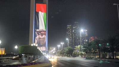 Images of the national flag and Sheikh Zayed bin Hamdan with fellow soldiers are projected on to the Adnoc building on the Abu Dhabi Corniche to honour the grandson of Sheikh Zayed on his return to the country on February 17, 2018 after months of treatment abroad for injuries suffered while serving in Yemen. Khushnum Bhandari / The National