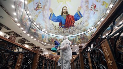 A member of a medical team sprays disinfectant at a church in Cairo. EPA