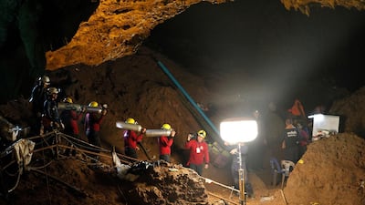 Thai officials carry oxygen tanks through a cave complex during a rescue operation for a missing football team at the Tham Luang cave. Pongmanat Tasiri / EPA