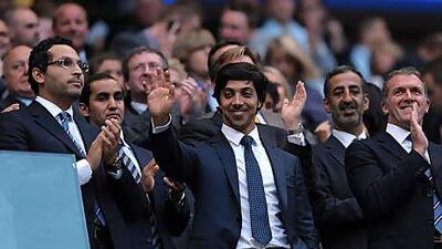Sheikh Mansour bin Zayed, centre, with Khaldoon Khalifa al Mubarak, left, received a rapturous welcome from Manchester City fans at the game against Liverpool at the City of Manchester Stadium on Monday night. It was the first time Sheikh Mansour had watched a game at Eastlands.
