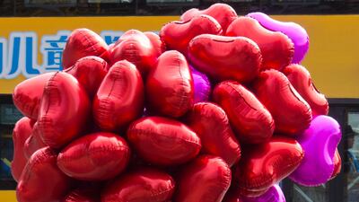 A cyclist transports heart shaped balloons for sale to those marking Valentines Day in Beijing, China. Although China has its own traditional festival celebrating lovers the commercial drive behind the western style of celebrating St Valentine's Day has f???