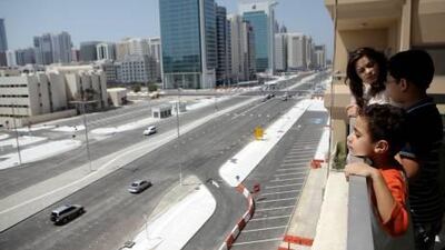 The Osman siblings, Ameera, 16, Omar, 12, and Ali, 5, look out at an unusual sight – cars – on their part of Salam Street.