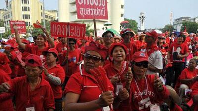 Red-shirted anti-government protesters dance near the government quarter in Bangkok, Thailand, on Friday, March 19, 2010.