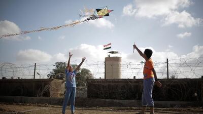 Palestinian children fly a kite at the border between Egypt and Gaza Strip in Rafah town, southern Gaza Strip. Ali Ali / EPA
