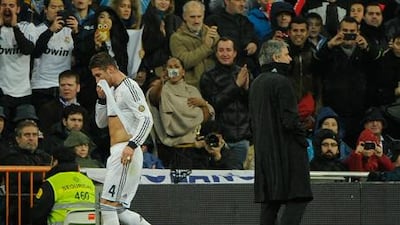 Real Madrid defender Sergio Ramos walks off the field past Jose Mourino after his red card against Ray Vallecano.