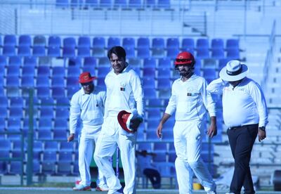 Rashid Khan, second left, took three wickets to leave the UAE struggling at 100-5 at close of play on Day 2 against Afghanistan in their Intercontinental Cup match at the Zayed Cricket Stadium on Thursday. Amith Passela for The National