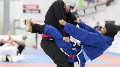 Maitha Harasi, black, fights Shamsa Hasan, during a Female Blue Adult 55KG match at Al Ain Jiu Jitsu Open Championship. Reem Mohammed / The National