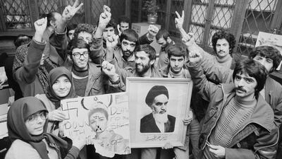 A group of anti-monarchy students hold pictures of the Shah and his wife as they celebrate the end of his rule, in the UK in January 1979. Getty Images