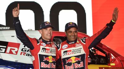Toyota Gazoo Racing's Qatari driver Nasser al-Attiyah (R) and his French co-driver Matthieu Baumel wave during the podium ceremony in Jeddah ahead of the 2020 Dakar Rally. AFP