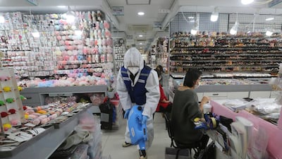 A worker wearing protective gears sprays disinfectant inside a shop in Seoul. AP Photo