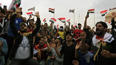 Iraqi protesters chant slogans and carry the national flag during a demostration in Karbala. EPA