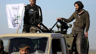 Turkish-backed Syrian rebels stand on the back of a truck in the Manbij countryside. Reuters