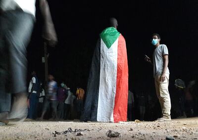 A Sudanese demonstrator wears a national flag during an anti-government protest in the Haj Yousef neighbourhood of the Bahari district in the capital Khartoum. AFP