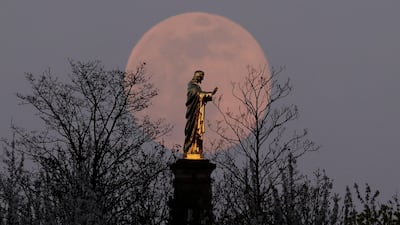 The pink supermoon rises behind the Sacre-Coeur du Horn statue of Christ, in Wolxheim, near Strasbourg, France. Reuters