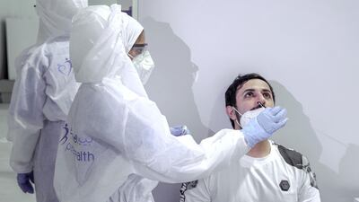 A nurse conducts a nasal swab test on a UAE government employee. Victor Besa / The National.
