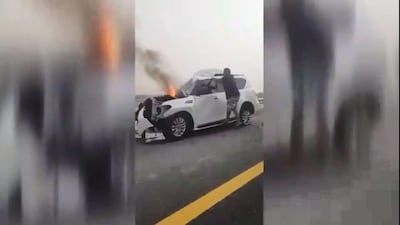 An off duty police officer works to rescue a driver trapped in his burning car on Saturday. Courtesy: Dubai Police