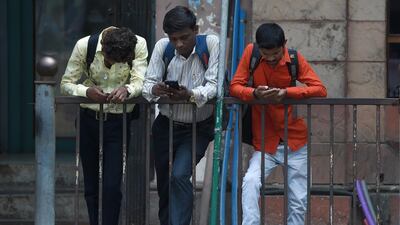 Indian men check their smartphones outside the Bombay Stock Exchange (BSE) in Mumbai. AFP