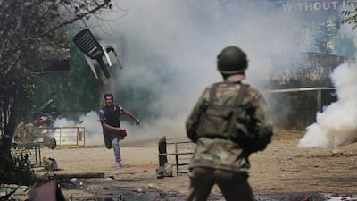 A Kashmiri student throws a chair towards Indian security forces during clashes in Srinagar. Mukhtar Khan / AP