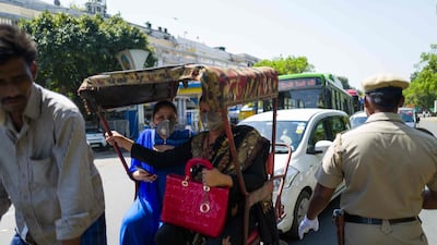 A policeman checks motorists at a roadblock during the first day of a 21-day government-imposed nationwide lockdown, in New Delhi. AFP