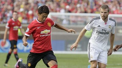 Shinji Kagawa of Manchester United, left, prepares to play the ball as Asier Illarramendi, right, of Real Madrid tails him during their match on Saturday at Michigan Stadium in the US. Duane Burleson / Getty Images / AFP