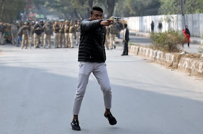 An unidentified man brandishes a gun during a protest against a new citizenship law outside the Jamia Millia Islamia university in New Delhi, India. Reuters